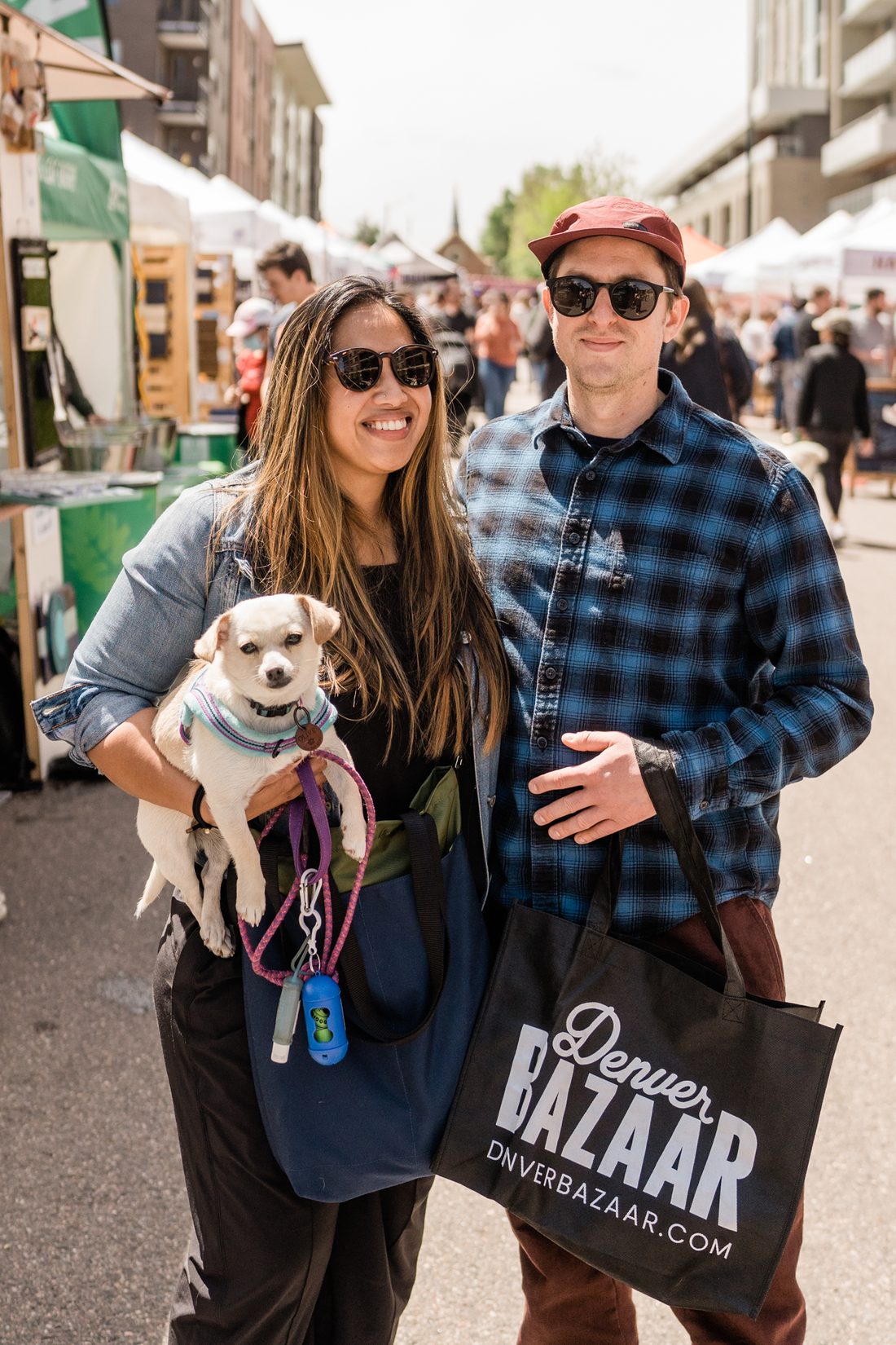 Two shoppers pose with their small dog and a Denver BAZAAR tote.